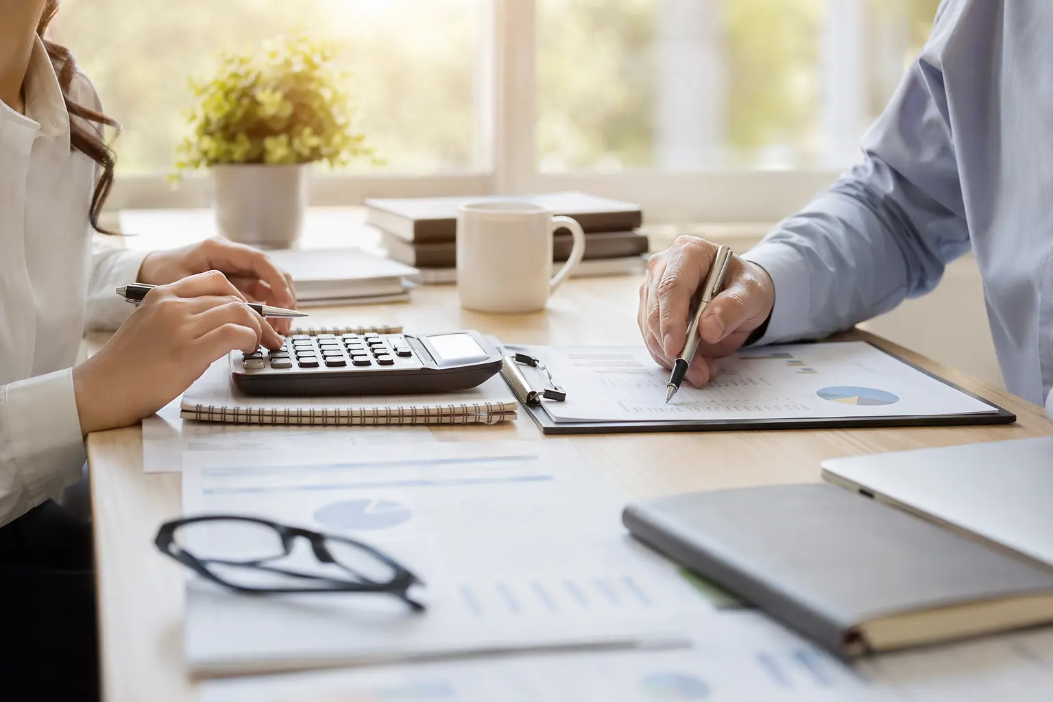 Solo for Tax Preparers — Person reviewing documents with calculator and laptop.