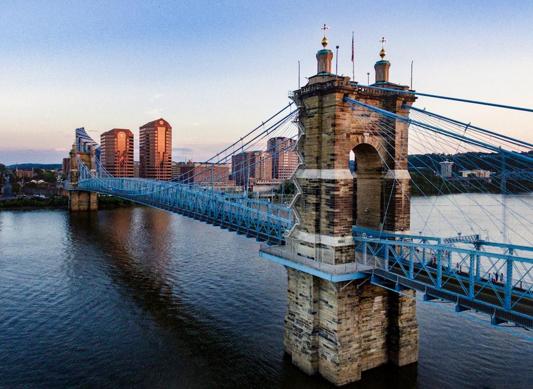 Cincinnati skyline with iconic blue suspension bridge over Ohio River at dusk