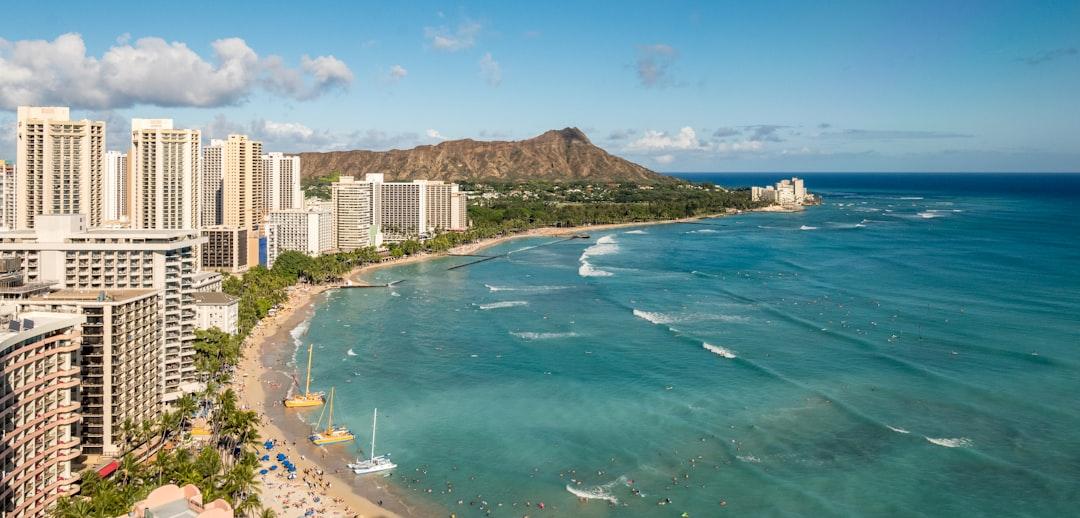 Waikiki Beach coastal view with high-rise hotels, turquoise ocean waters, and Diamond Head mountain in background