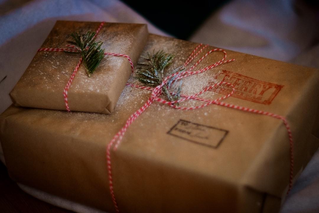Kraft paper packages tied with red twine and evergreen sprigs, decorated for holiday gift-giving and seasonal marketing